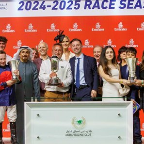 Ryan Tongue (right of trophy in blue suit), director of Deva Racing, celebrates Imperial Emperor's win the 2025 Al Maktoum Classic at Meydan Racecourse