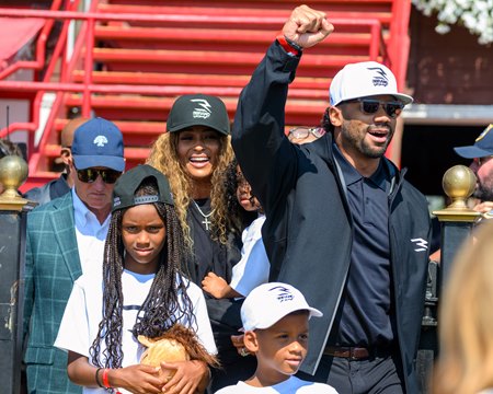 Russell Wilson (right), surrounded by his family, heads into the winner's circle after Club Reign's victory at Saratoga Race Course
