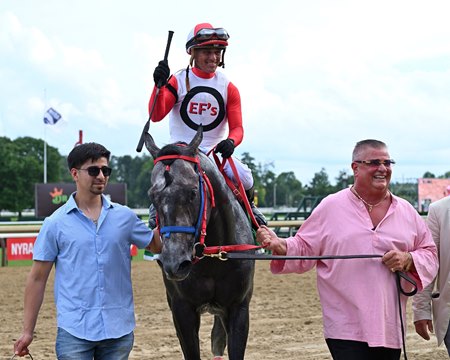 Eddie Fazzone (right) leads Buttah into the winner's circle after his victory in the John Morrissey Stakes at Saratoga Race Course